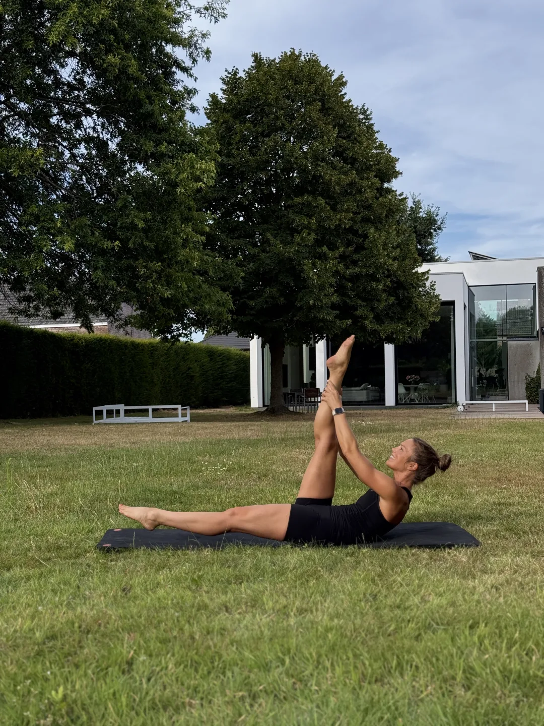Fie doet buiten een buikspieroefening op haar Pilatesmat