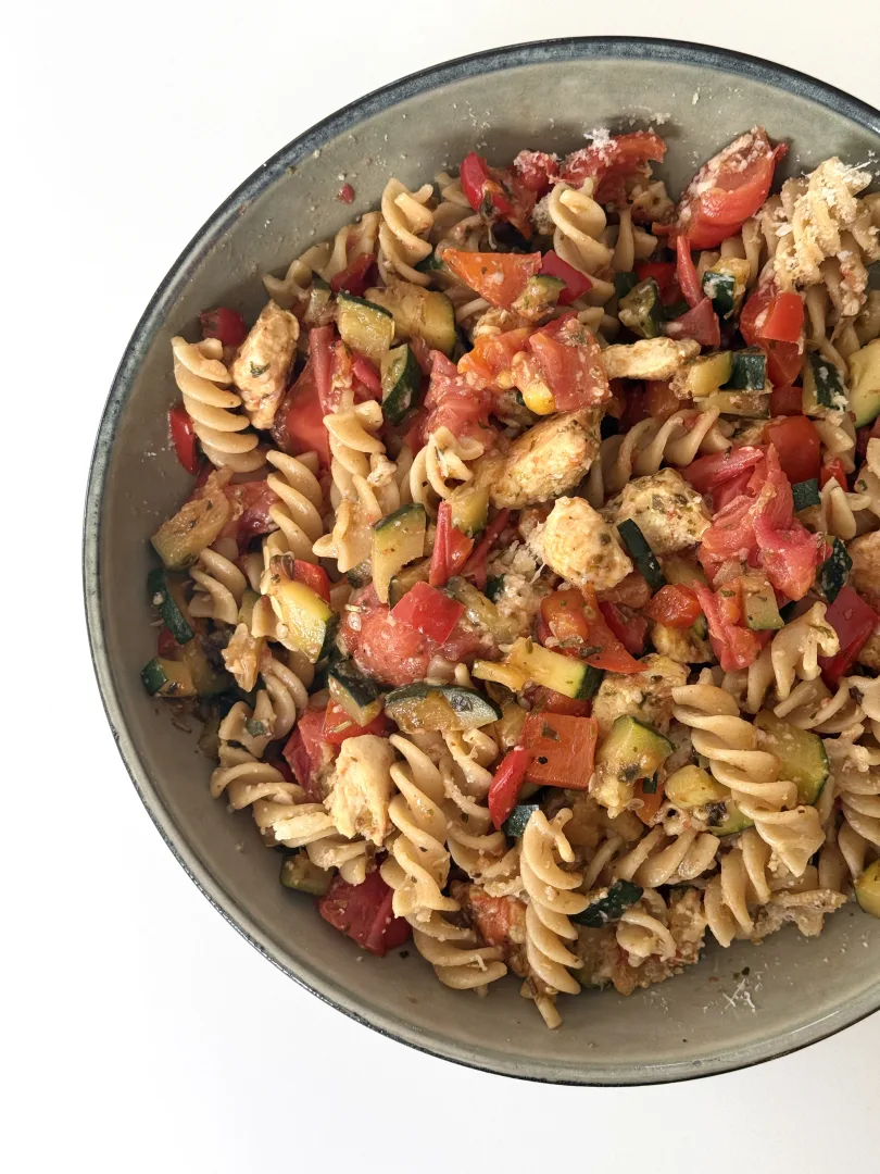 Pasta met kip, courgette en tomaat in een schaal