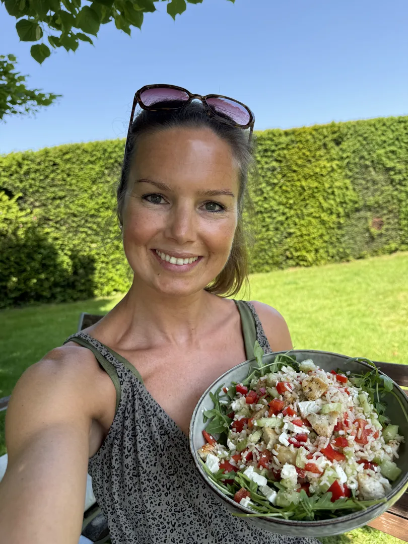 Fie houdt een kom met salade vast in de tuin